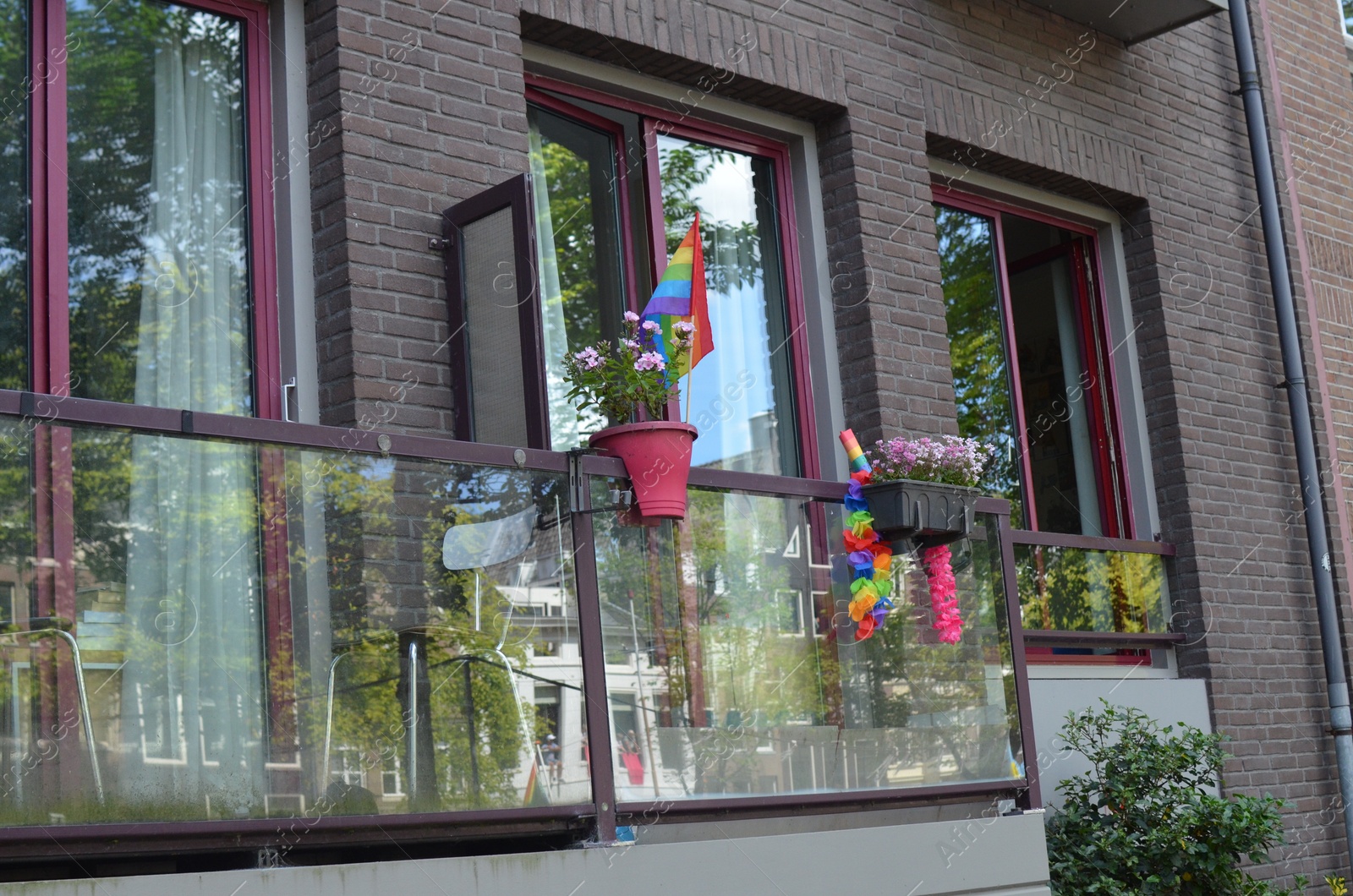 Photo of Bright rainbow LGBT pride flags on building balcony outdoors