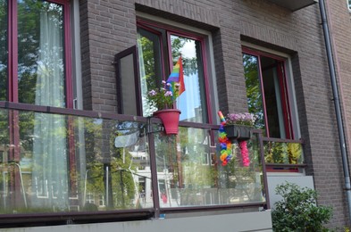 Bright rainbow LGBT pride flags on building balcony outdoors