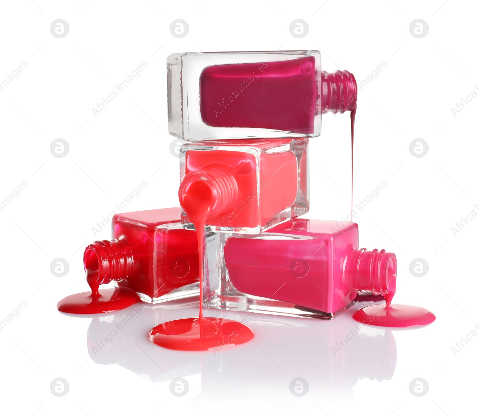 Photo of Spilled different nail polishes with bottles on white background