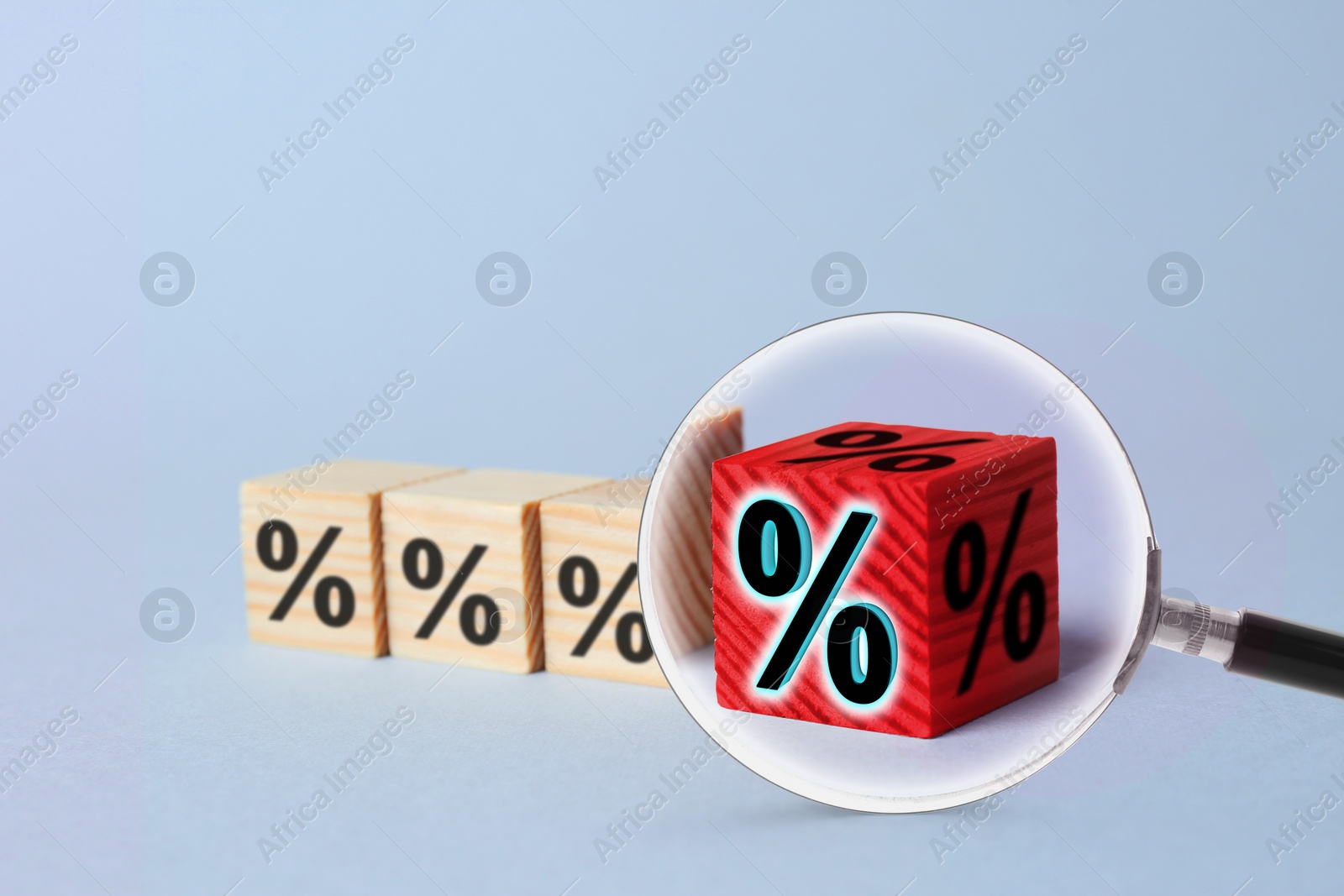 Image of Best mortgage interest rate. Red cube with percent sign among wooden ones on light background, view through magnifying glass