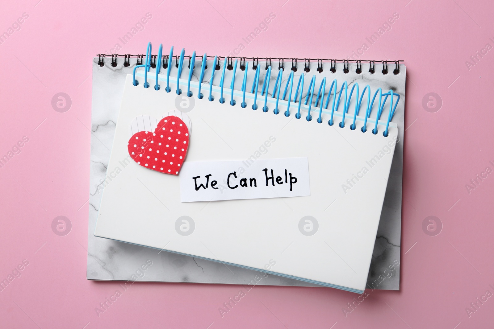 Photo of Notebooks and card with words WE CAN HELP on color background, top view