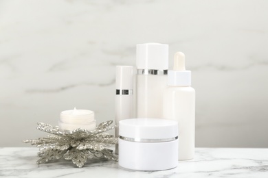 Photo of Beautiful composition with cosmetic products on white marble table. Winter care