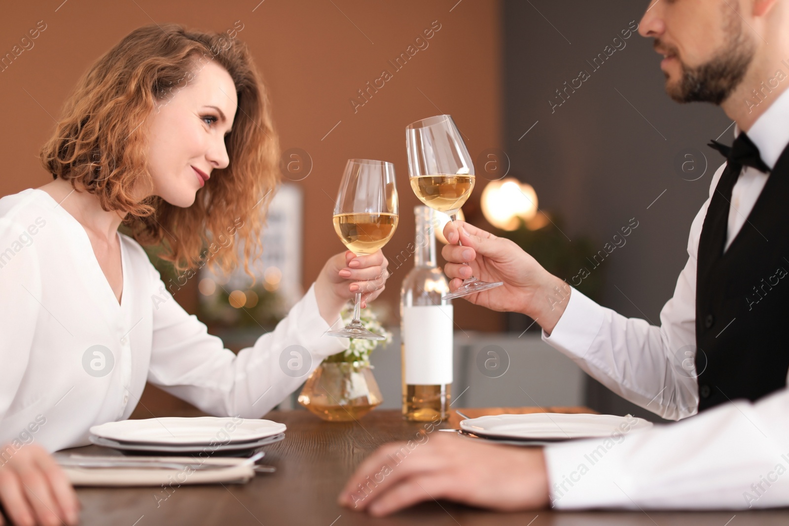 Photo of Young couple with glasses of delicious wine in restaurant