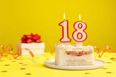 Photo of Coming of age party - 18th birthday. Delicious cake with number shaped candles on yellow background, space for text