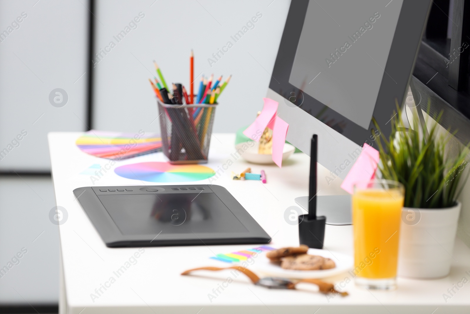 Photo of Modern designer's workplace with graphic tablet and computer