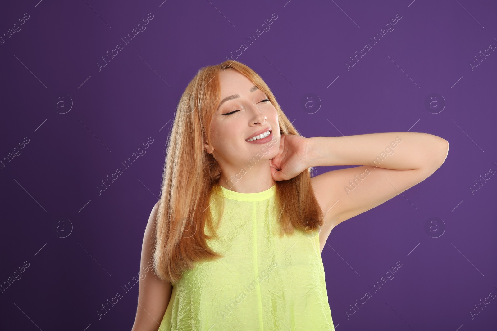 Photo of Beautiful young woman with blonde hair on purple background