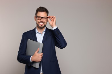 Photo of Happy teacher with glasses and stationery against beige background. Space for text