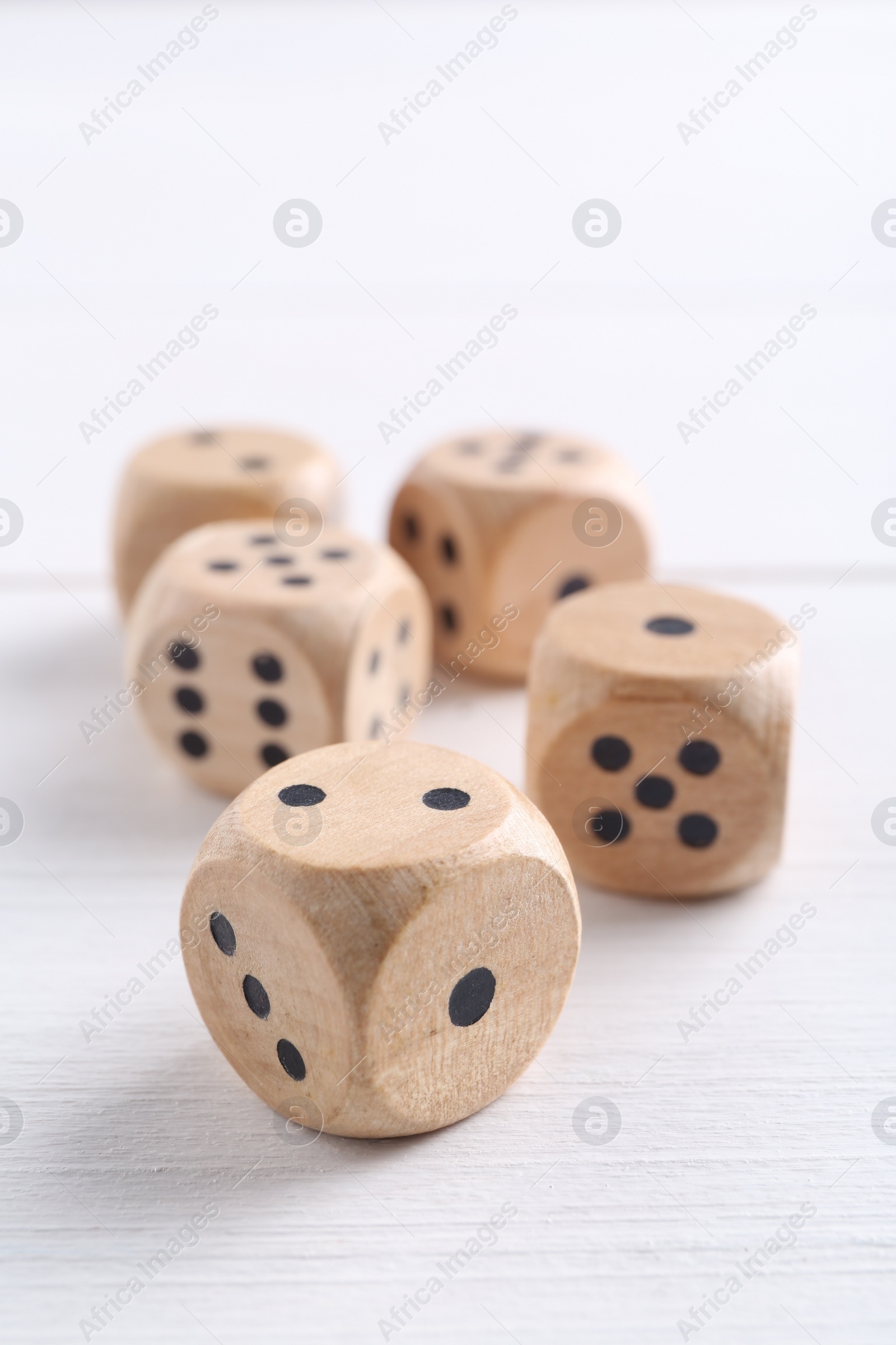 Photo of Many game dices on white wooden table, closeup