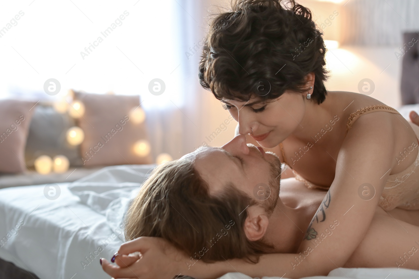 Photo of Lovely young couple being intimate on bed at home