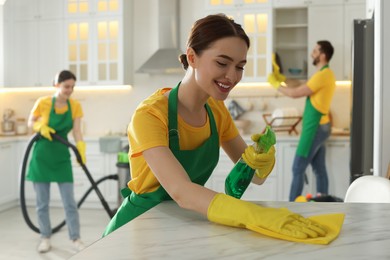 Photo of Team of professional janitors working in kitchen
