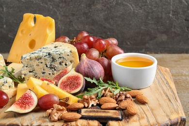 Set of different snacks with ripe figs served on wooden board