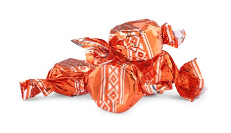 Photo of Candies in orange wrappers isolated on white