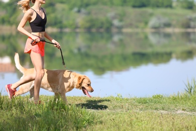 Young woman and her dog spending time together outdoors. Pet care