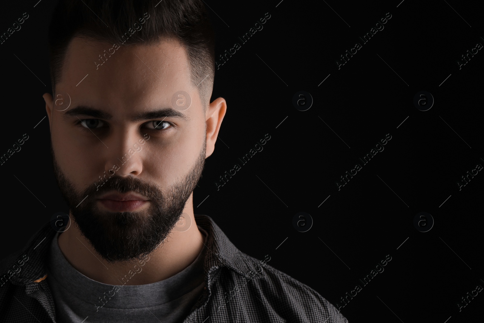Photo of Evil eye. Man with scary eyes on black background, space for text