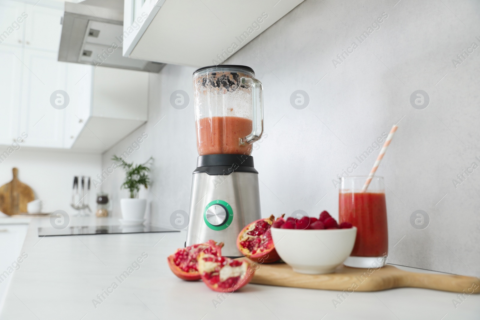 Photo of Blender and smoothie ingredients on white countertop in kitchen. Space for text