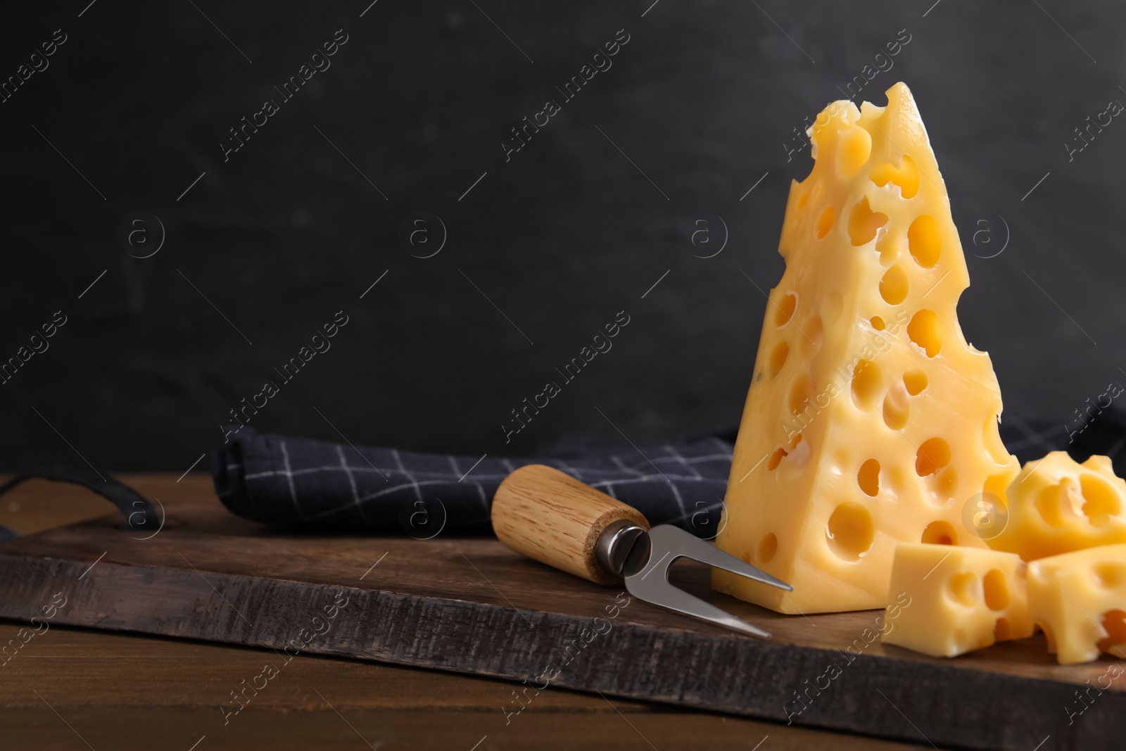 Photo of Tasty fresh cheese with fork on wooden table, space for text