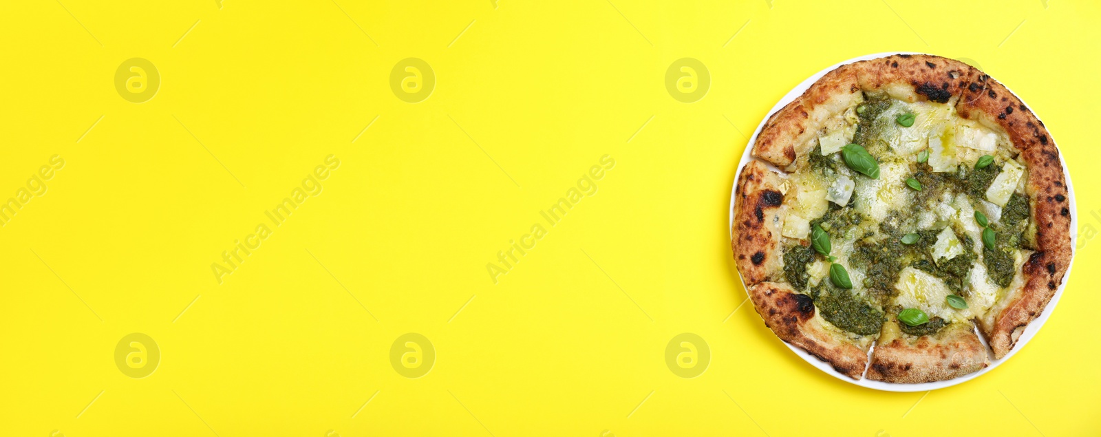 Image of Delicious pizza with pesto, cheese and basil on yellow background, top view with space for text. Banner design