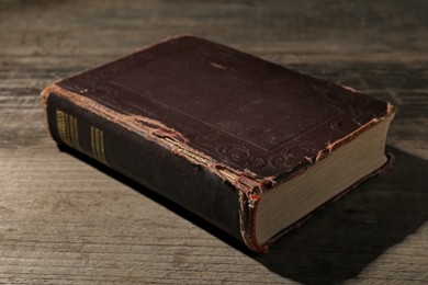 Photo of One old hardcover book on wooden table, closeup