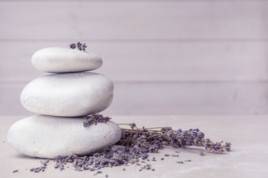 Photo of Spa stones with lavender flowers on table