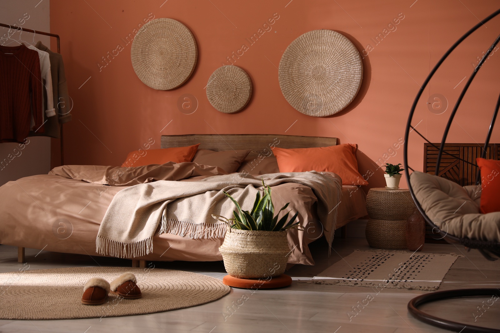 Photo of Bed with orange and brown linens in stylish room interior