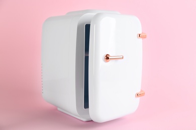 Mini refrigerator for cosmetics on pink background