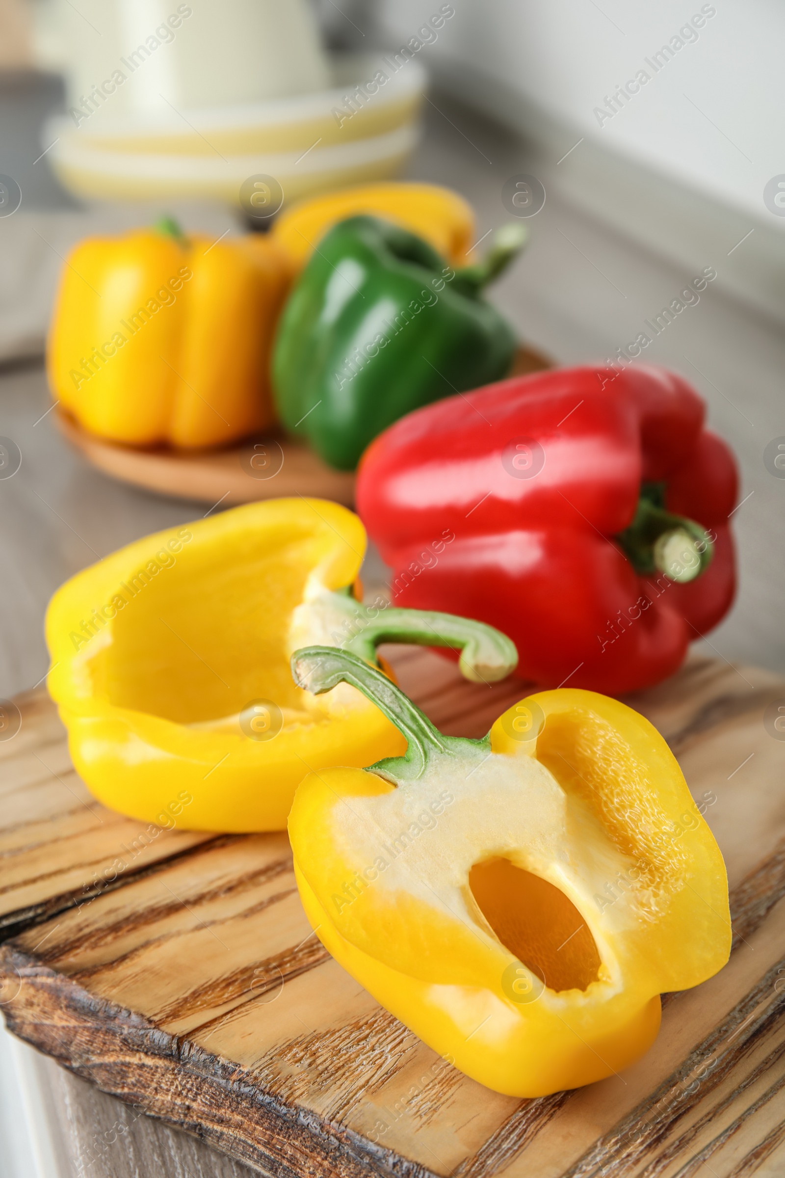 Photo of Wooden board with ripe paprika peppers on table, closeup