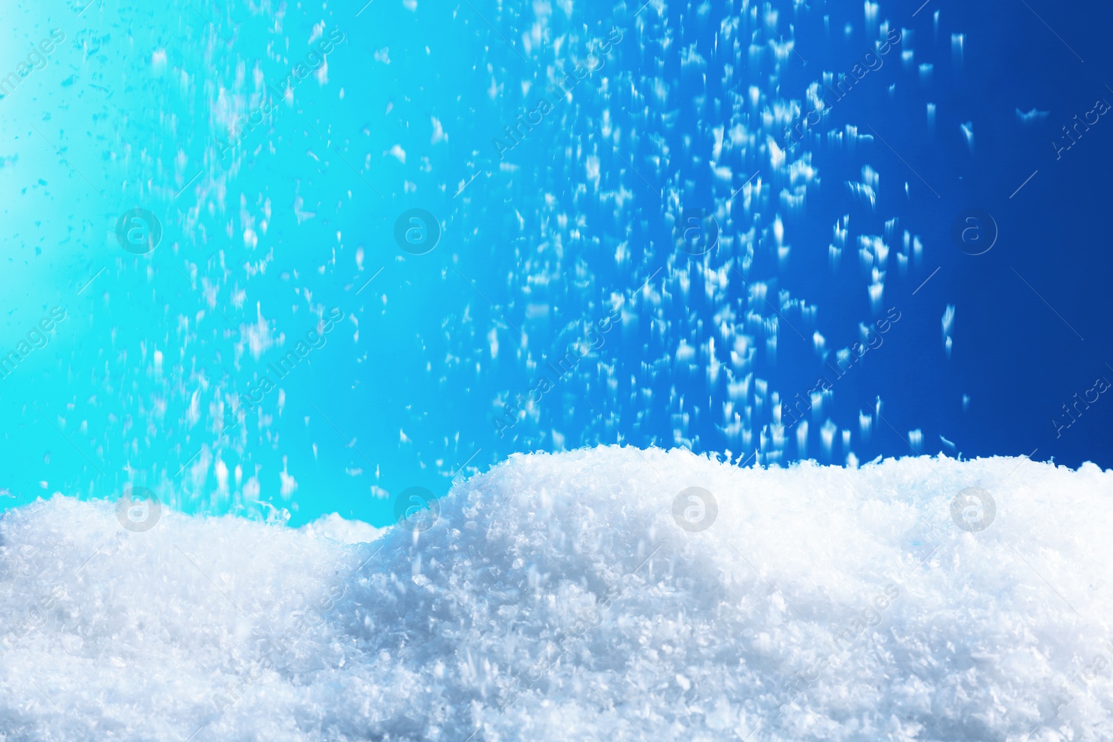 Photo of Snow flakes falling on blue background. Winter weather