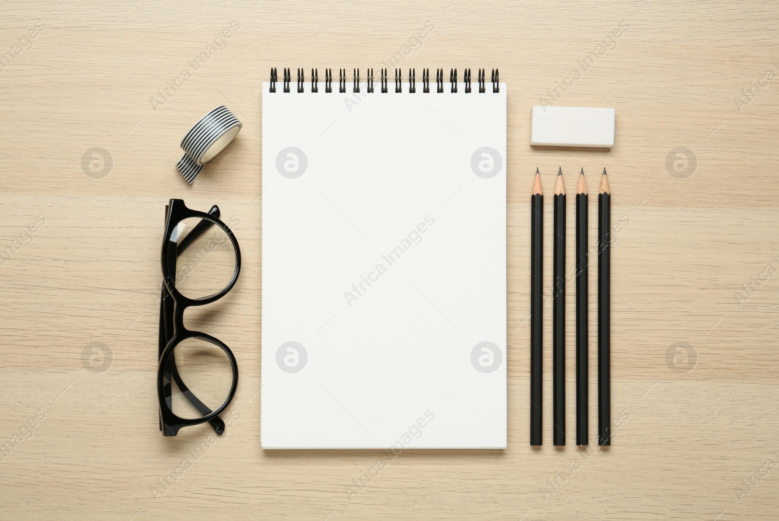 Photo of Flat lay composition with blank sketchbook on wooden table. Space for text