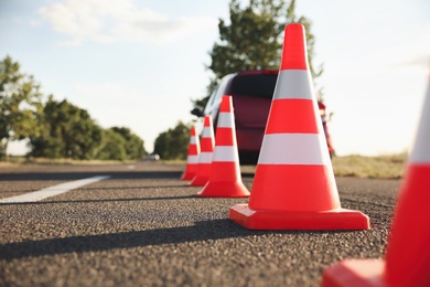 Photo of Traffic cones near car outdoors. Driving school exam