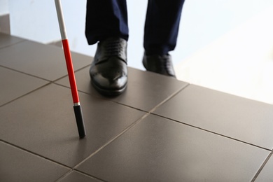 Photo of Blind person with long cane going up stairs, closeup