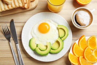 Delicious breakfast with fried egg served on wooden table, flat lay