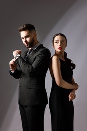 Handsome bearded man with sexy lady on grey background