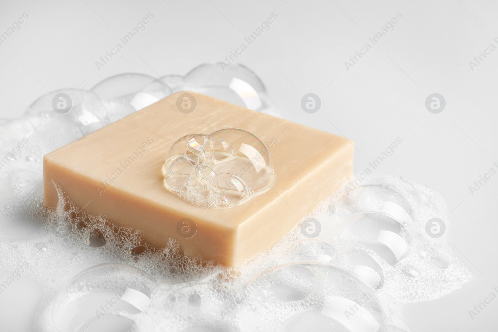 Photo of Soap bar and foam on white background