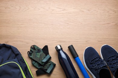 Flat lay composition with different cycling accessories on wooden background, space for text