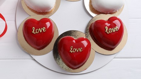 Photo of St. Valentine's Day. Delicious heart shaped cakes on white wooden table, top view