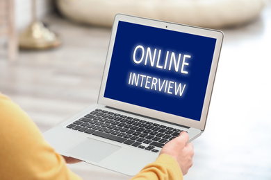 Image of Woman using laptop for online interview indoors, closeup 
