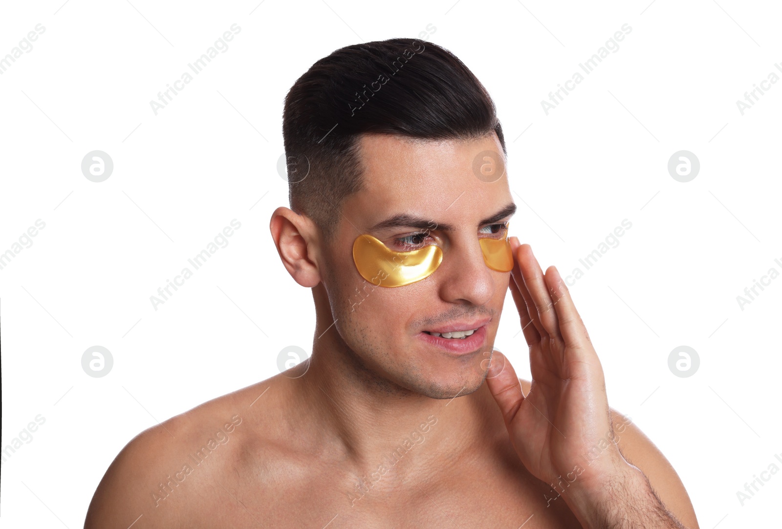 Photo of Man applying golden under eye patch on white background