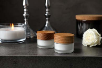 Photo of Jars with cream on black table. Cosmetic product