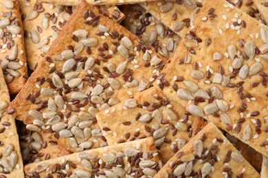 Cereal crackers with flax, sunflower and sesame seeds as background, top view