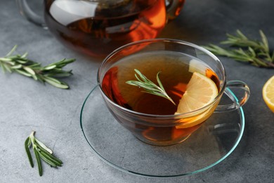 Photo of Aromatic herbal tea with rosemary and lemon on grey table