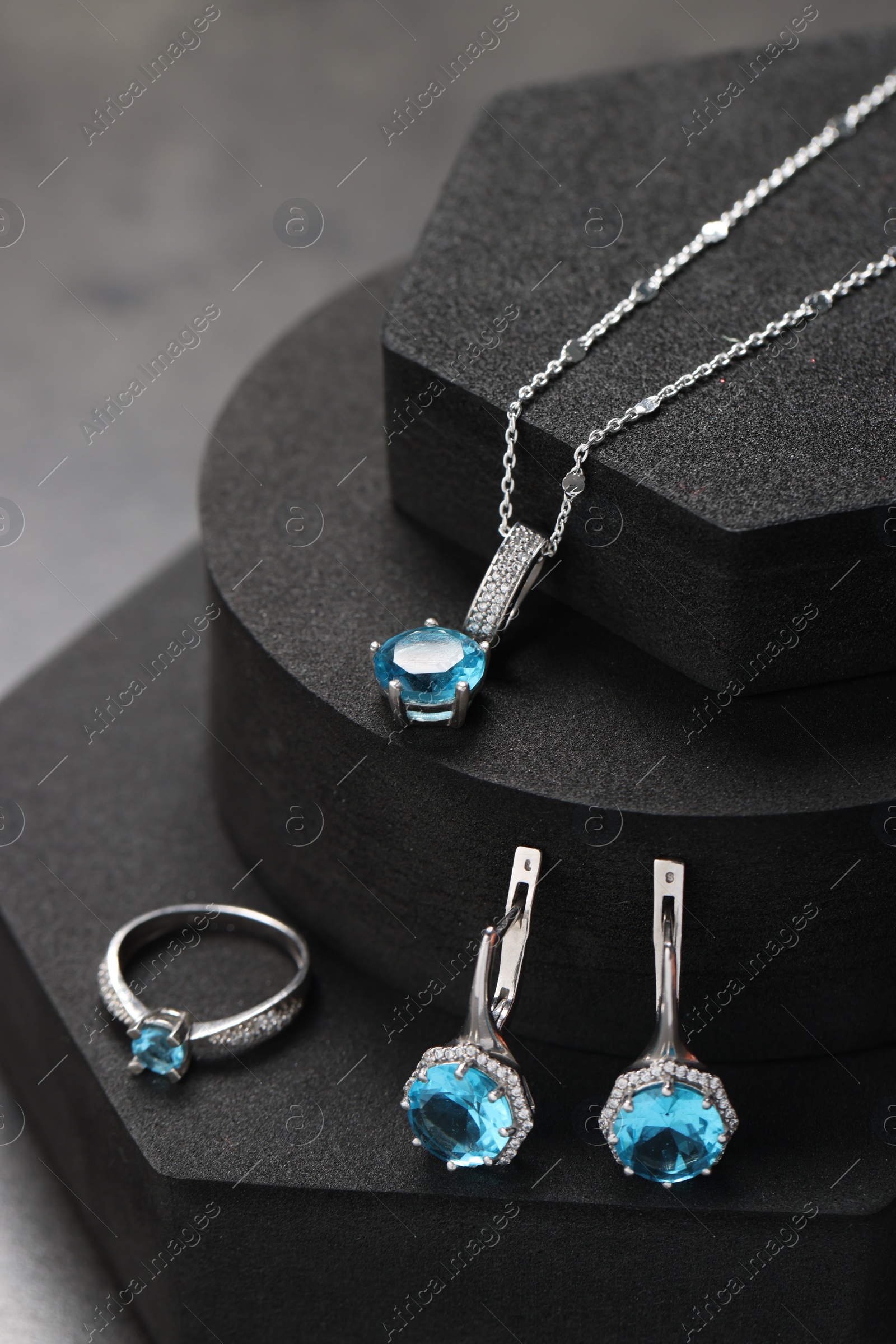 Photo of Beautiful jewelry with light blue gemstones on black podiums