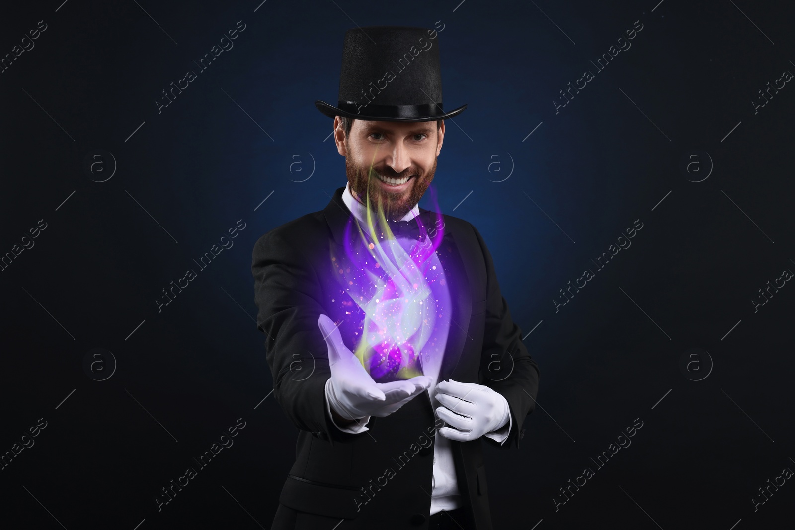 Image of Magic and sorcery. Magician with fantastic light on dark background