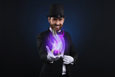 Magic and sorcery. Magician with fantastic light on dark background