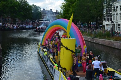 AMSTERDAM, NETHERLANDS - AUGUST 06, 2022: Many people in boat at LGBT pride parade on river