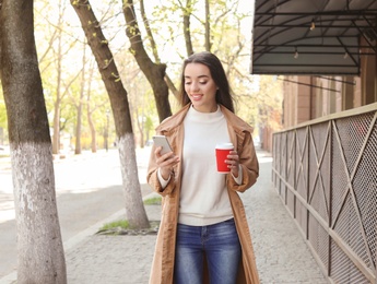 Photo of Young woman using phone outdoors on sunny day