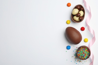 Photo of Flat lay composition with chocolate Easter eggs and space for text on white background