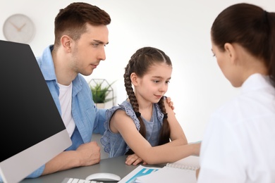 Photo of Young man with his daughter having appointment at child psychologist office