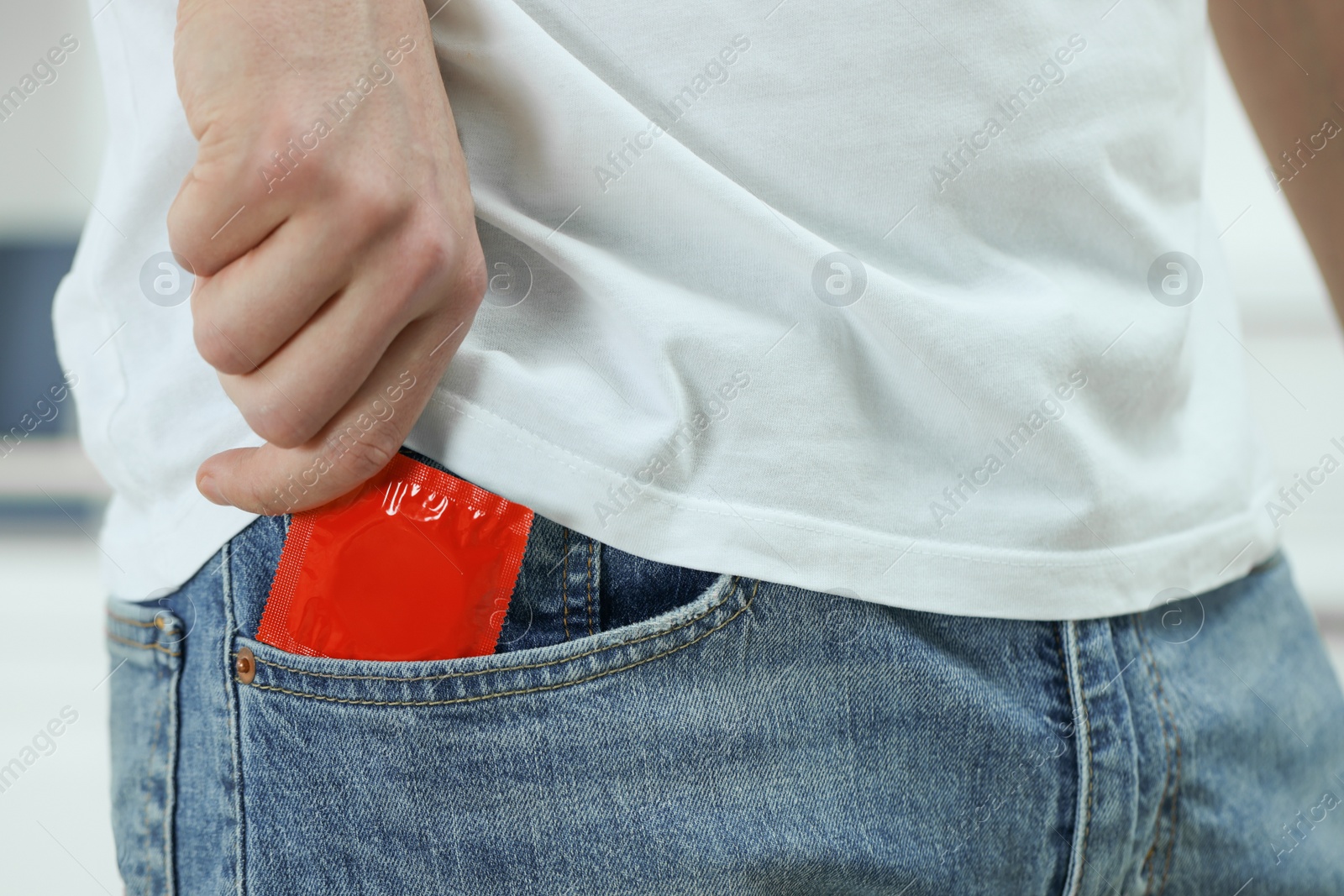 Photo of Man pulling condom out of pocket, closeup