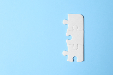 Photo of Blank white puzzle pieces on light blue background, flat lay. Space for text