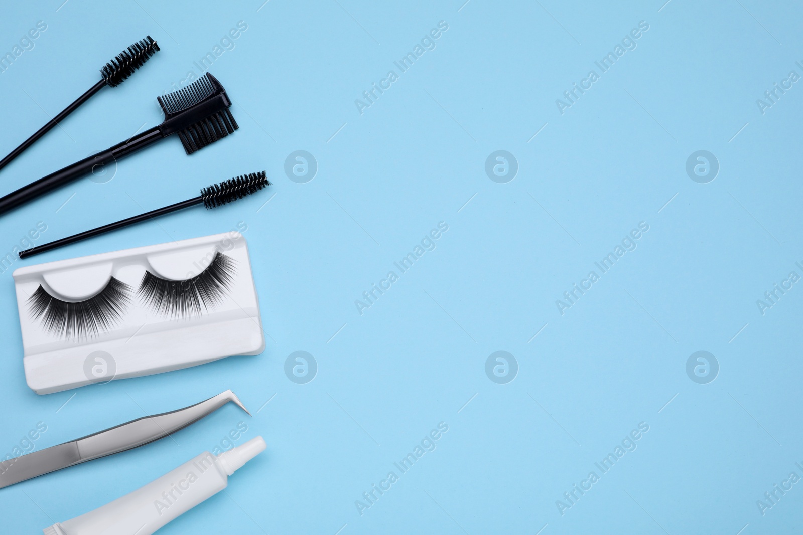 Photo of Flat lay composition with fake eyelashes on light blue background, space for text